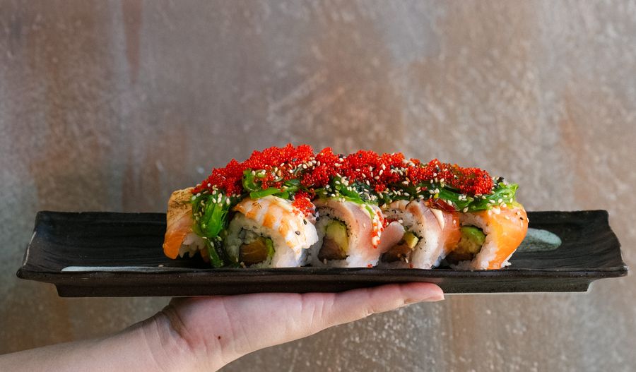 Sushi Roll mit rotem Tobiko auf einer Platte