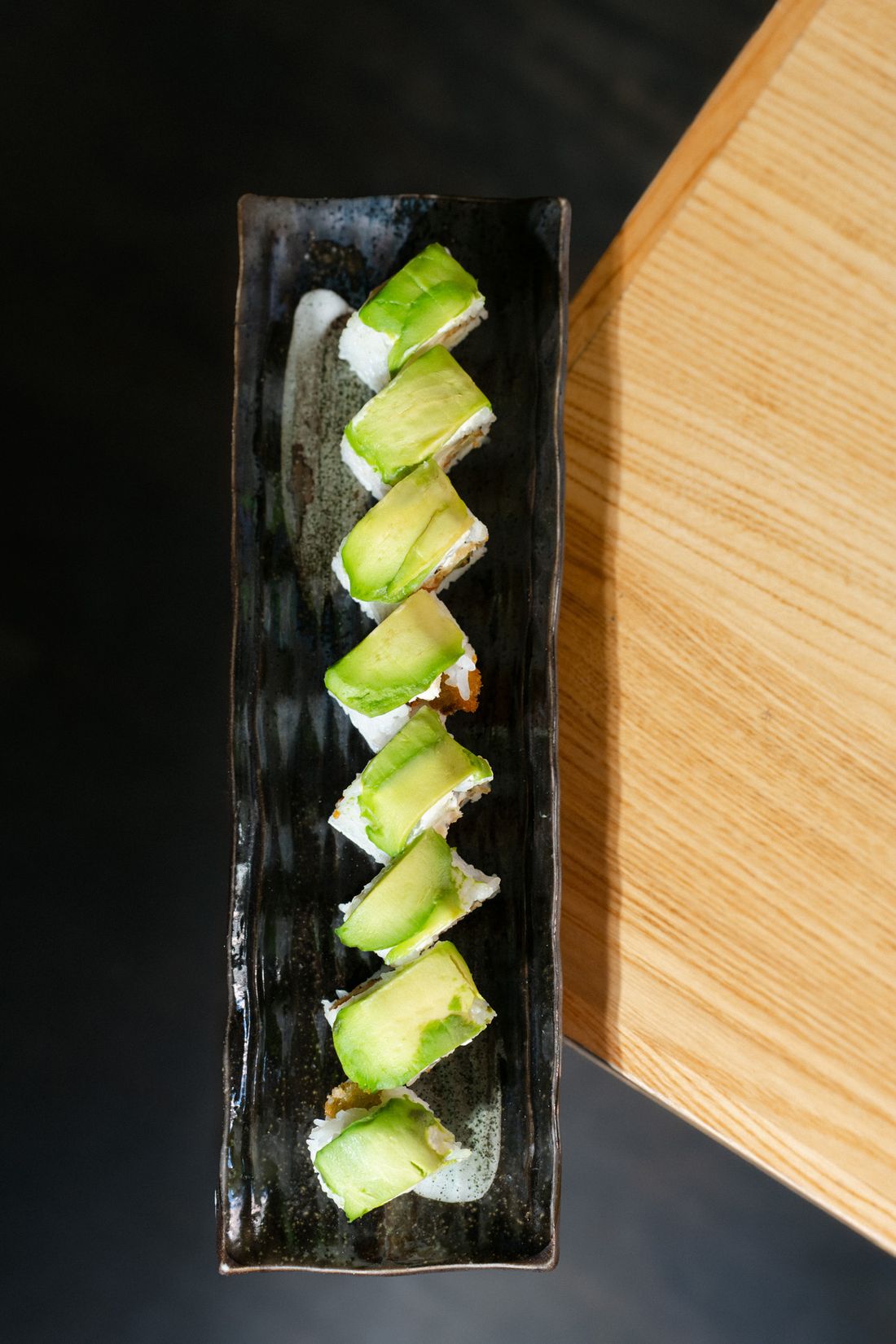 Avocado Inside Out Roll auf schwarzer Platte